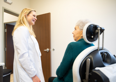 Dr. Caroline Morris meeting with a patient in Cedar Rapids to performing a cosmetic dermatology consultation.